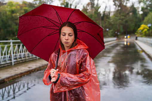 Woman with umbrella standing on the autumn rain