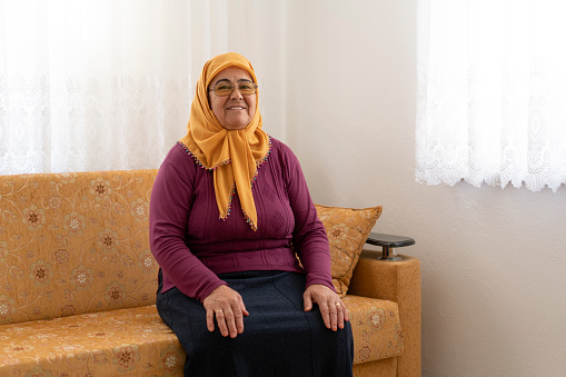 Portrait of senior woman sitting on a sofa in living room, Mugla Turkey