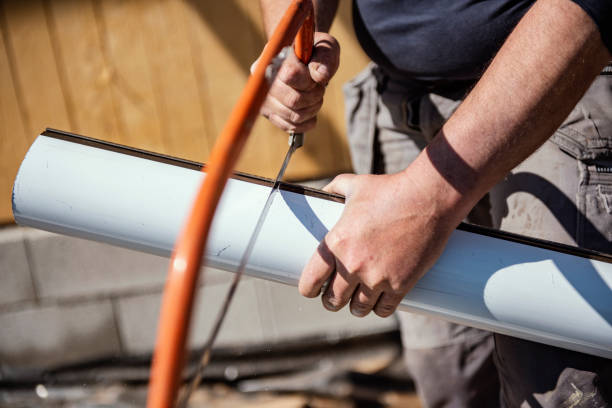 istock Roofer cutting roof gutter with  hand saw 1312413291