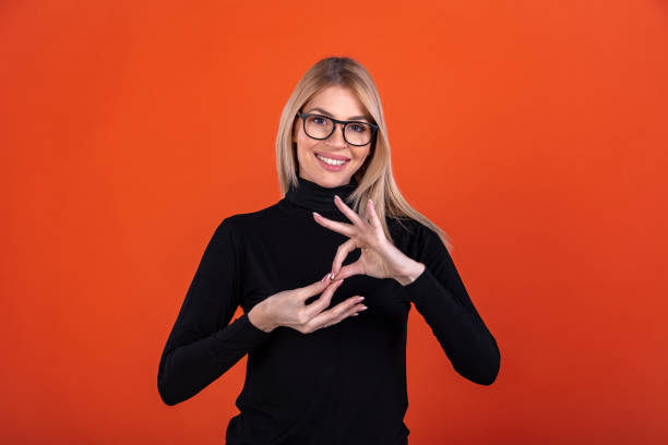 foto de una mujer sorda gesticulando en lenguaje de señas - physical impairment smiling front view looking at camera fotografías e imágenes de stock