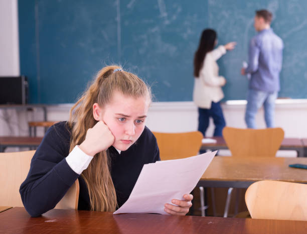 istock Frustrated girl student sitting in classroom with paper 1312416672