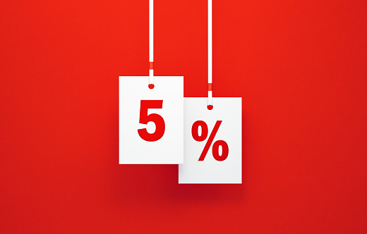 5 percent off written white price tags hanging from white ribbons over red background. Horizontal composition. Sale concept.