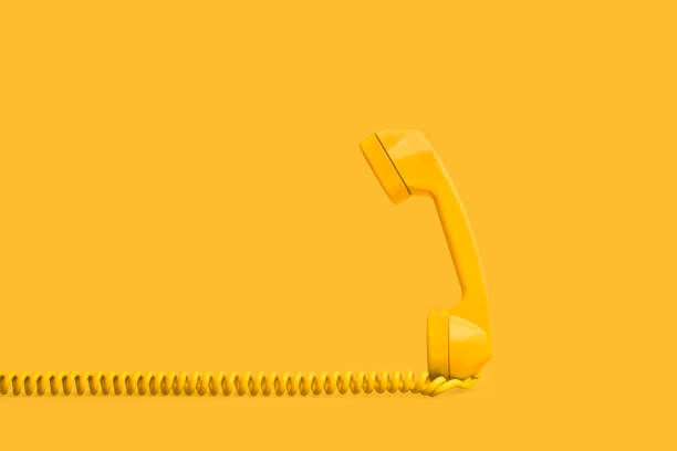 istock An old yellow telephone receiver on a blue background 1312422266