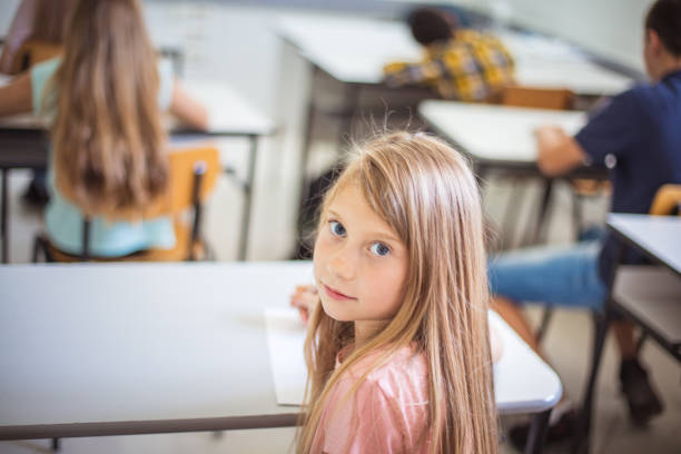 istock Teenagers students sitting in the classroom. Focus is on foreground. 1312423341