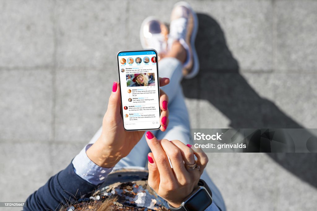Vrouw die sociale media microblogging app op haar telefoon met behulp van - Royalty-free Sociaal netwerk Stockfoto