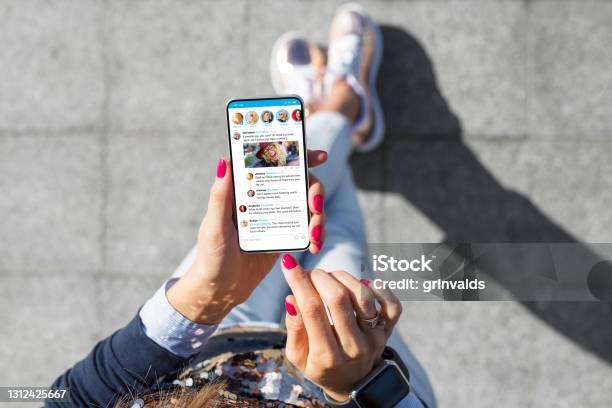Woman Using Social Media Microblogging App On Her Phone Stock Photo - Download Image Now
