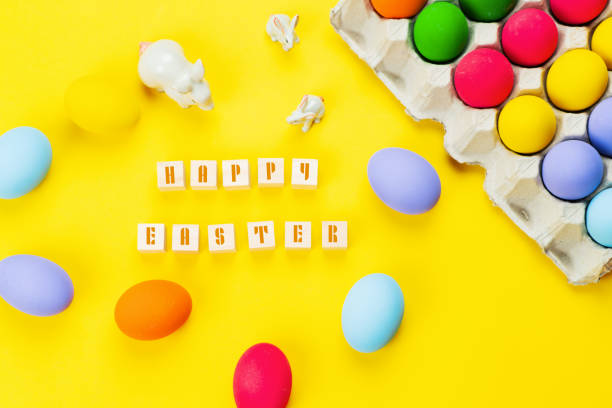 istock Easter day little Bunny rabbit with decorated eggs on yellow background 1312425811