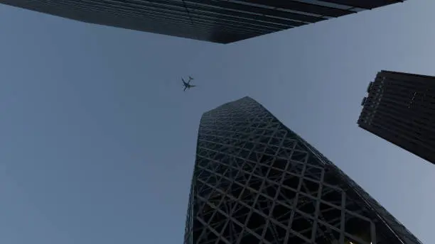 An airplane flying over a skyscraper
