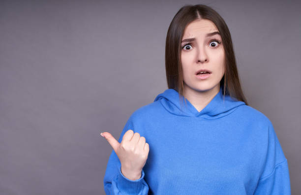 istock A funny surprised young lady points her finger to the side. 1312426145