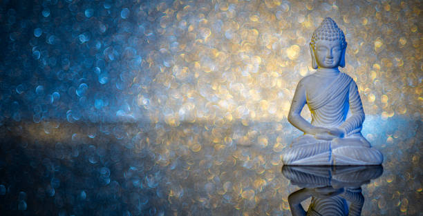 istock illuminated stone Buddha statue on acrylic underground in front of an illuminated background 1312426542