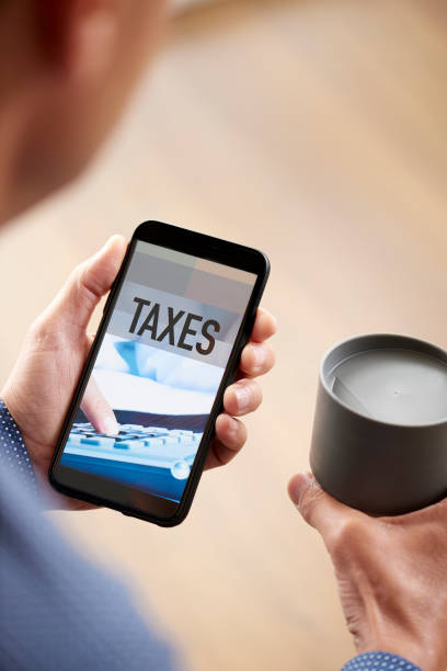istock man and smartphone with text taxes in its screen 1312427805