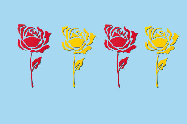 some roses made with cutouts of red and yellow papers, on a blue background, for saint george day, when it is tradition to give roses in catalonia, spain