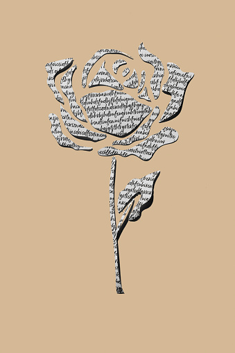 a rose made with cutouts of a non-sense written paper, on a brown background, for saint george day, when it is tradition to give roses and books in catalonia, spain