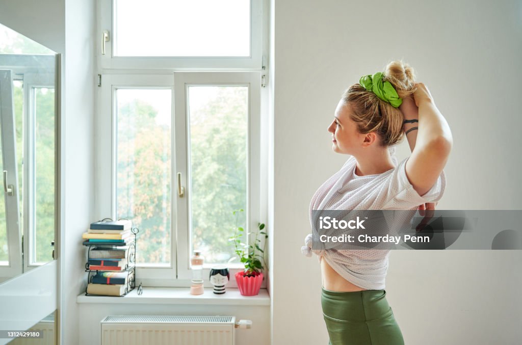 Prepare well so you can perform well Shot of a young woman stretching her arms while exercising at home 20-29 Years Stock Photo
