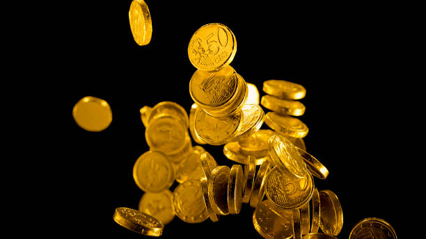 gold foil wrapped chocolate euro coins falling - chocolate coins imagens e fotografias de stock