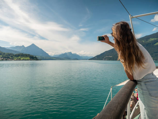 młoda kobieta lubi jeździć łodzią po jeziorze, robi zdjęcia telefonem komórkowym - switzerland nautical vessel interlaken swiss culture zdjęcia i obrazy z banku zdjęć