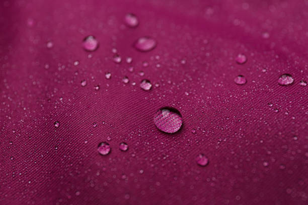 istock Dark pink waterproof fabric with water drops as background, closeup 1312439692