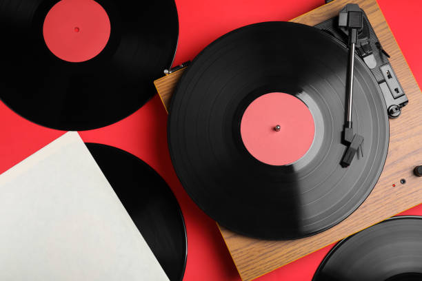 赤の背景に現代のプレーヤーとビニールレコード、フラットレイ - record ストックフォトと画像