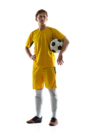 Portrait of Caucasian man, male soccer football player in yellow uniform with football ball isolated on white background. Concept of active life, team game, energy, sport. Copy space for ad.