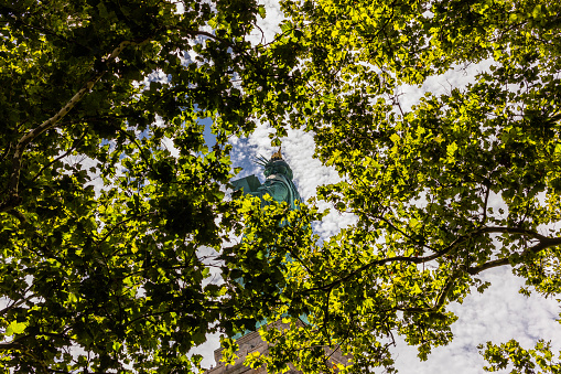 New York City, United States - August 23, 2017: View of the Statue of Liberty through the tree branches.