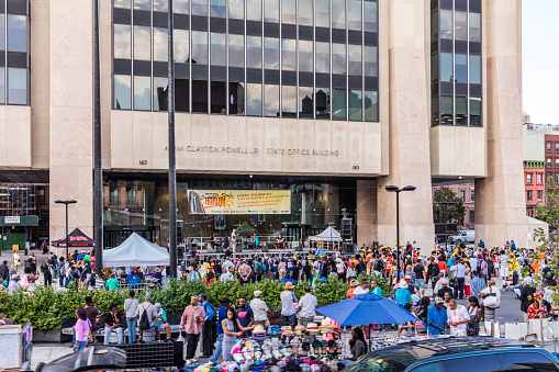 New York City, United States - August 25, 2017: The Adam Clayton Powell Jr. State Office Building, Harlem neighborhood, Manhattan, with a band performing outdoors.