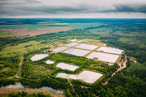 luftaufnahme retention basins, nassteich, nassrückhaltebecken oder regenwassermanagementteich, ist ein künstlicher teich mit vegetation um den umfang, und enthält einen permanenten pool von wasser in seinem design - detention center stock-fotos und bilder