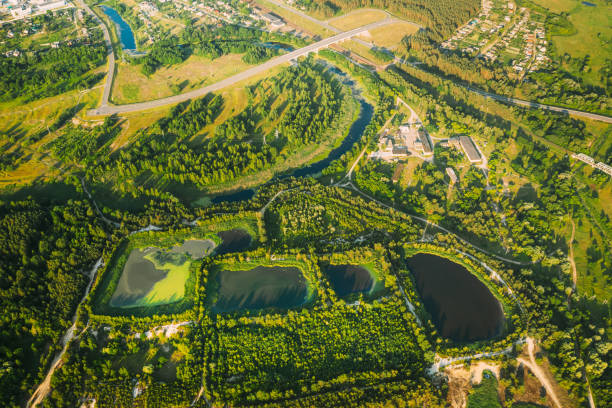 cuencas de retención de vistas aéreas, estanque húmedo, cuenca de detención húmeda o estanque de gestión de aguas pluviales, es un estanque artificial con vegetación alrededor del perímetro, e incluye una piscina permanente de agua en su diseño - water retention fotografías e imágenes de stock