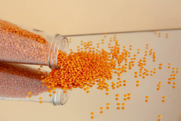 istock jar with scattered red lentils reflected in the mirror on an isolated background 1312446016