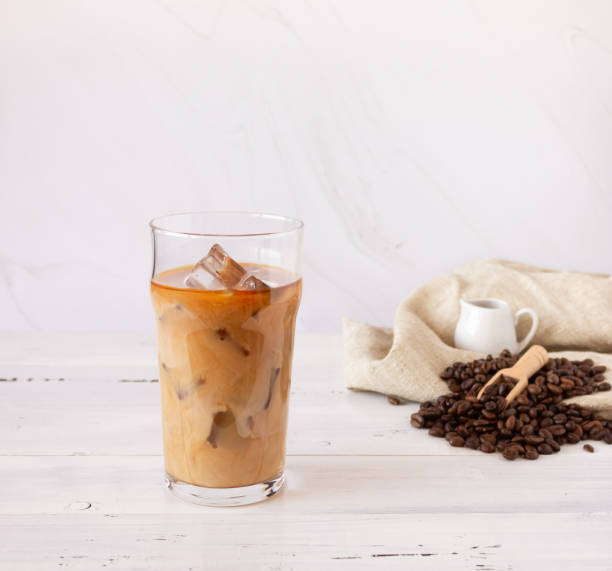 冷たいコーヒーと氷のグラスカップ、明るい背景にコーヒー豆。 - カフェラテ　アイス ストックフォトと画像
