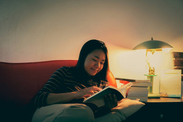 istock Young Woman Reading Book At Home 1312446989