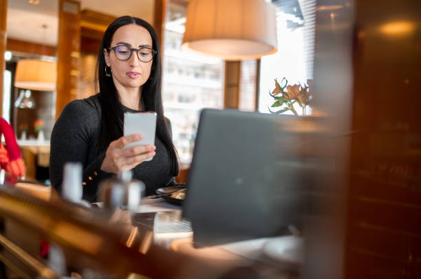 istock Female entrepreneur seen using her smart phone on a lunch break in her favorite restaurant that she also uses as a co-working space 1312448302