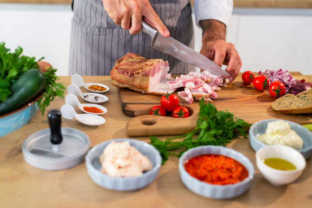 istock The cook is cutting bacon on a wooden board in kitchen 1312448414