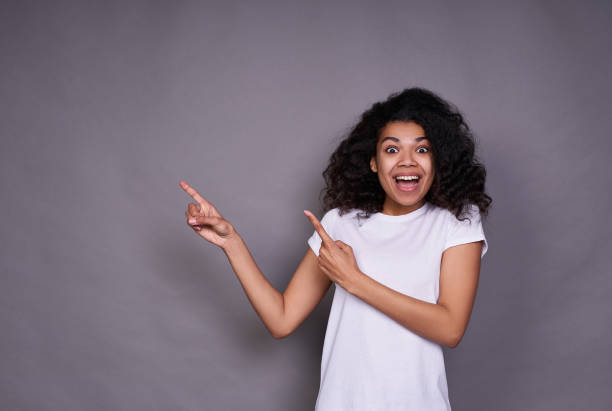 istock Joyful happy young African woman shows aside. 1312449603