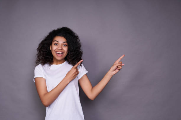 istock Joyful happy young African woman shows aside. 1312449729