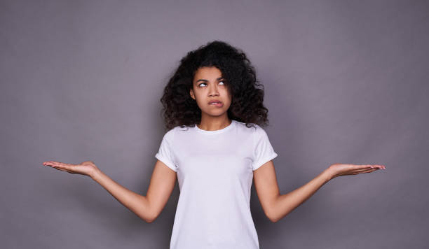istock Surprised young dark-skinned girl makes a choice, doubts. 1312449987