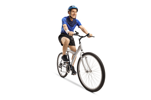Elderly male cyclist riding a bicycle with a helmet isolated on white background