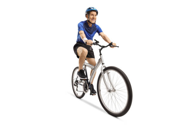 Elderly male cyclist riding a bicycle with a helmet Elderly male cyclist riding a bicycle with a helmet isolated on white background man 60s bicycle stock pictures, royalty-free photos & images