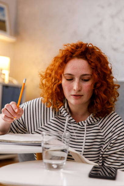 istock Doing homework and looking at phone while receiving text messages from friends 1312452131