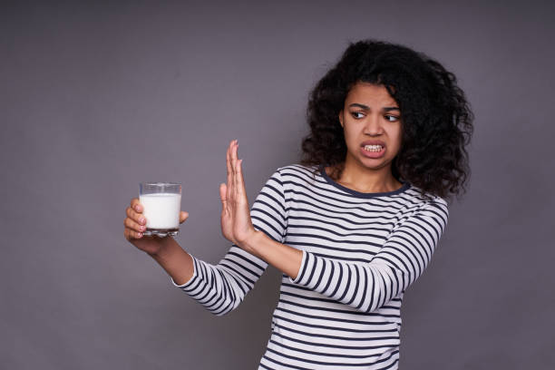 Portrait of a young dark-skinned girl who does not like milk. stock photo
