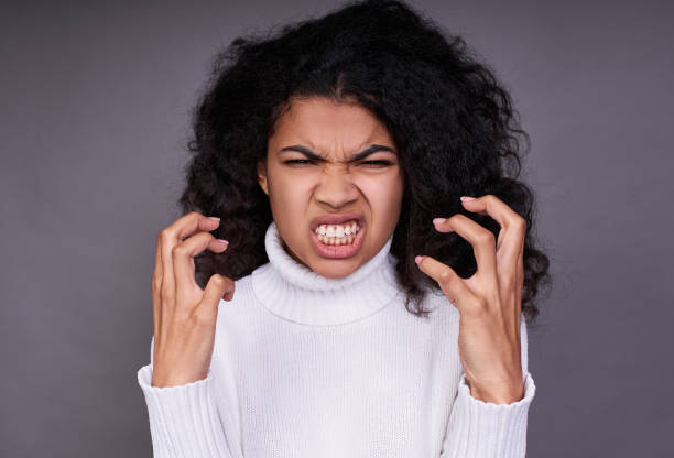 istock Angry dark-skinned young girl on a gray background. 1312456020
