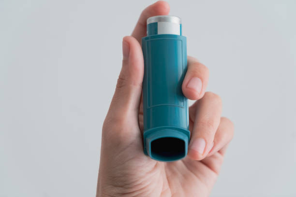 istock Human hand picking up an asthma inhaler 1312456300