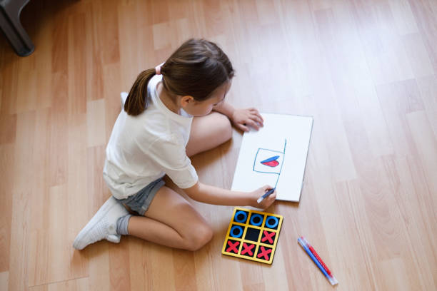 istock Little girl draws tic tac toe 1312456349