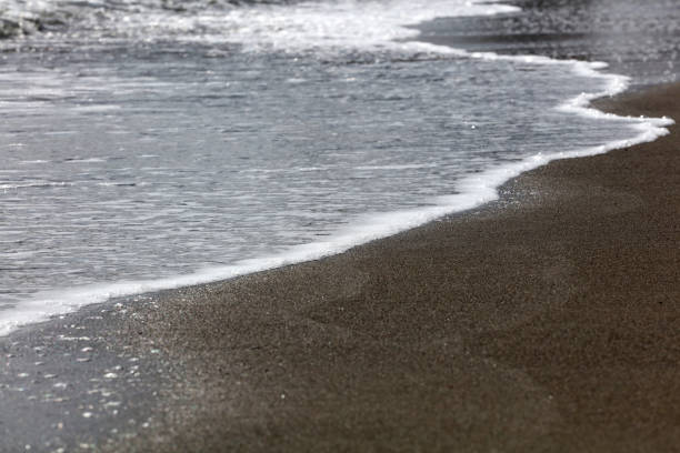 istock soft waves with white foam come ashore at sunset 1312456430