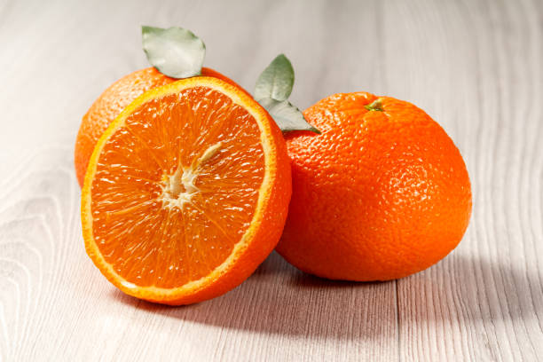 istock Cut orange in half on wooden background 1312456670