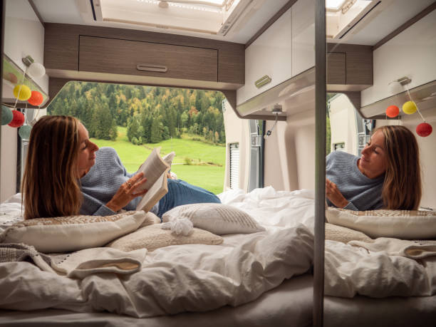 istock Serene woman reads her book inside a van overlooking alpine scenery 1312456780