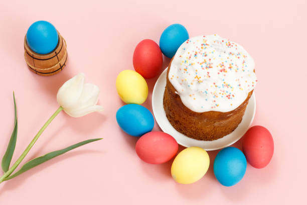 istock Easter cake on a plate, eggs and tulip flower with pink background. 1312457431