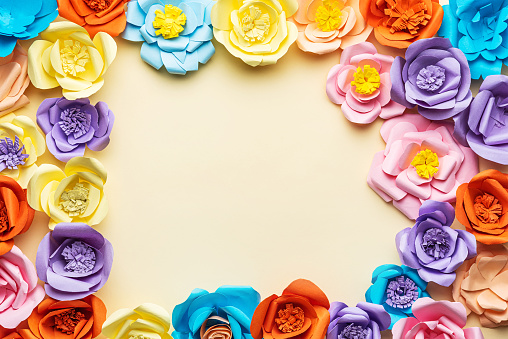 Colorful Paper Flower Arrangement on Yellow Background From Above