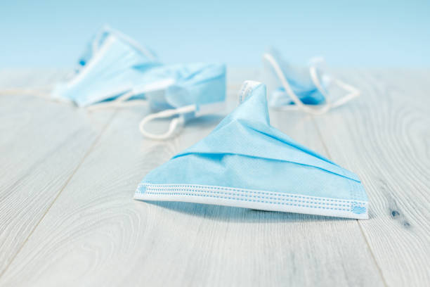 istock Used medical protective masks on a floor. 1312457576