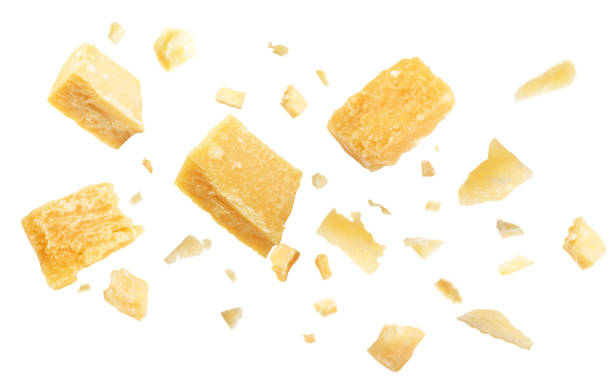 кусочки вкусного сыра пармезан, летящие на белом фоне - parmesan cheese стоковые фото и изображения