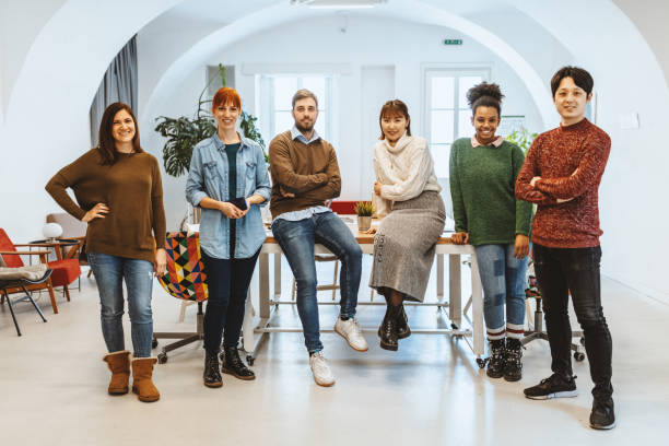 istock Multi ethnic business people standing in office, looking at camera 1312458666